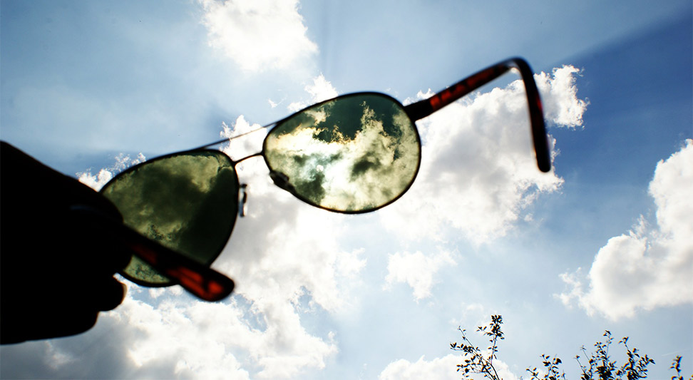 nJoy Vision Eye Health and UV Awareness Month blog post image of sunglasses darkening a bright sky