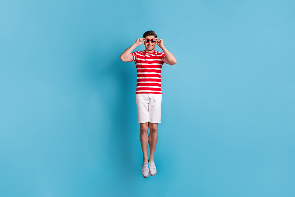 nJoy Vision Eye Health and UV Awareness Month feature image of summery young man jumping with sunglasses