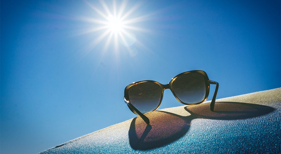 nJoy Vision OKC LASIK Blog UV Safety Awareness Month image of sunglasses and the bright sun