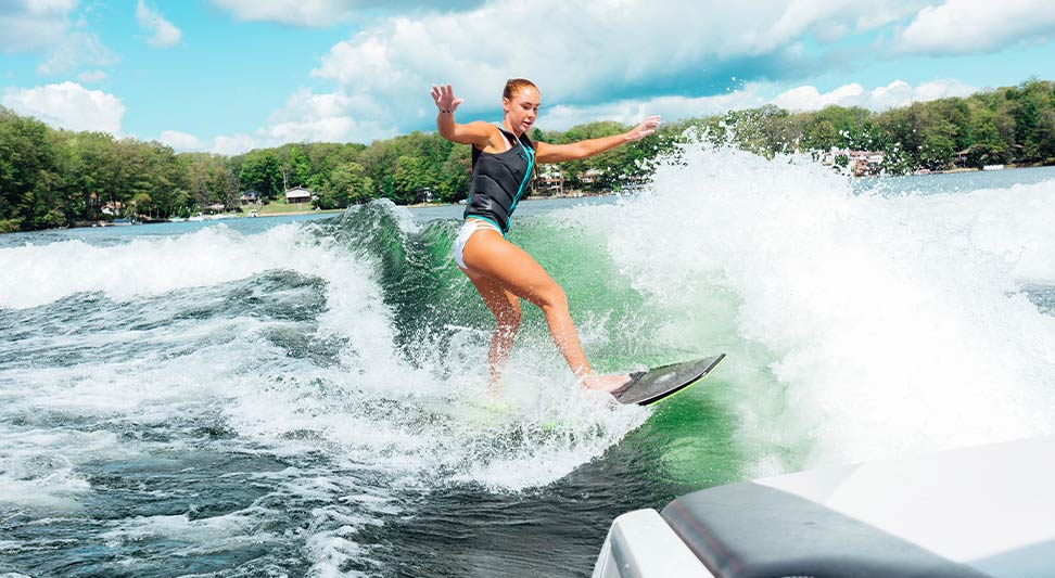 nJoy Vision Summertime is LASIK blog post story image of a young woman wake surfing behind a boat