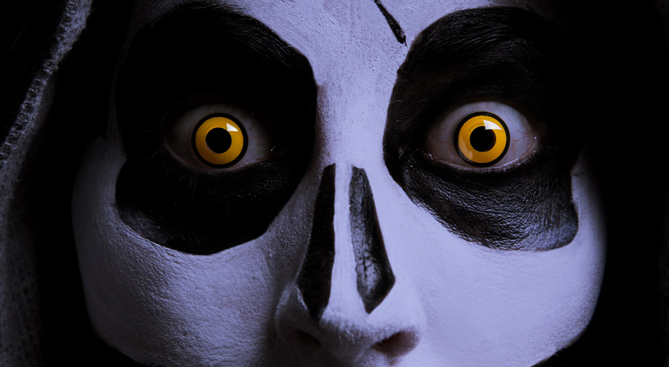 nJoy Vision Spooky Season Eye Safety blog post story image of a skeleton painted face with orange costume contacts