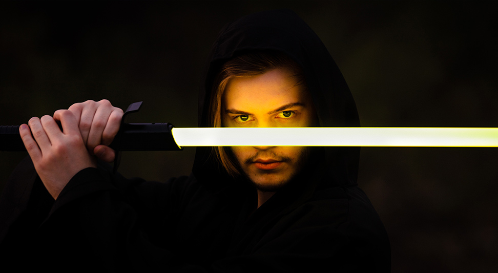 nJoy Vision Spooky Season Eye Safety blog post story image of a man holding a lightsaber